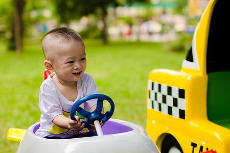 toddler riding car on grass field thumbnail