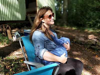 woman sitting on chair while carrying a child thumbnail