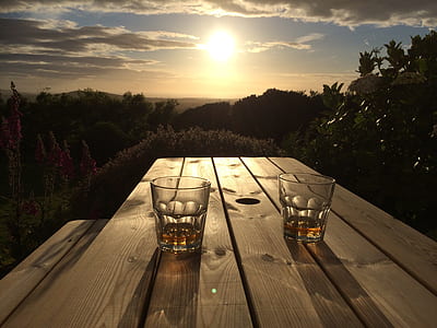 two clear drinking glasses on brown wooden table thumbnail