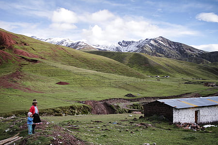 woman and girl standing on green mountains during daytime thumbnail