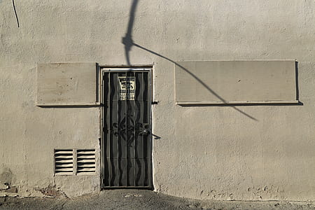 black metal door frame between gray concrete wall at daytime thumbnail