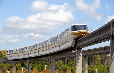 white train on railroad taken under white clouds during daytime thumbnail