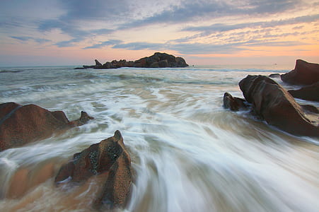 Brown Rocks Near a Body of Water during Daytime thumbnail
