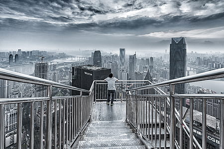 man in white shirt leaning on gray stainless steel balustrade thumbnail