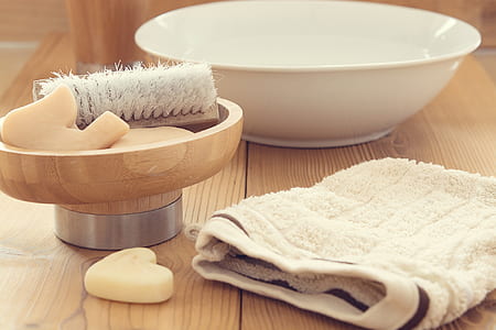 round white ceramic bowl beside beige towel on brown wooden surface thumbnail