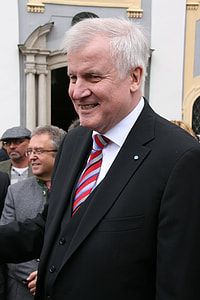 smiling man wearing black suit jacket during daytime thumbnail