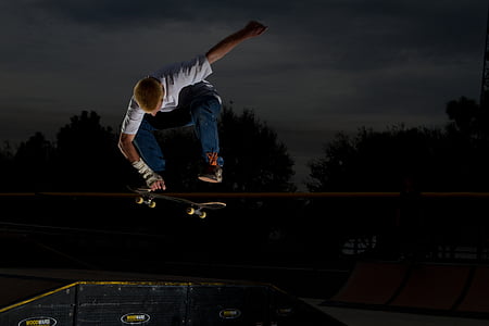 man in white shirt skateboarding during night thumbnail
