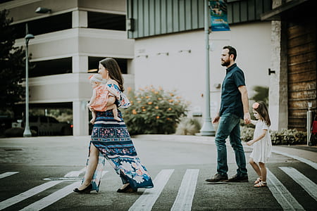 family of four walking on pedestrian lane during daytime thumbnail