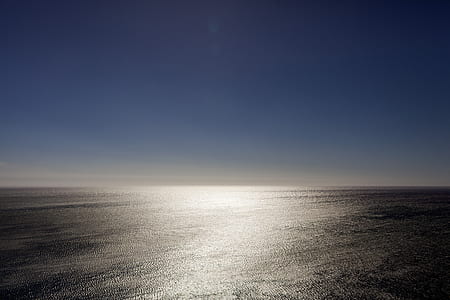 body of water under blue sky thumbnail