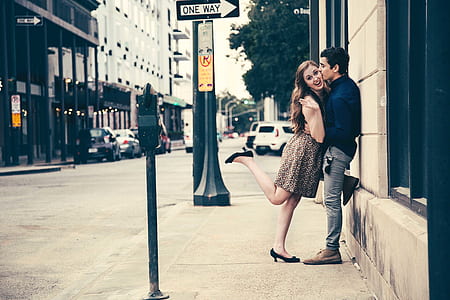 man and woman leaning on wall near street thumbnail