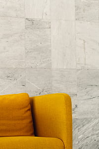 orange fabric sofa near gray marble wall thumbnail