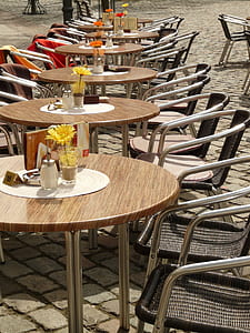 round brown tables and chairs with flowers and table runner thumbnail