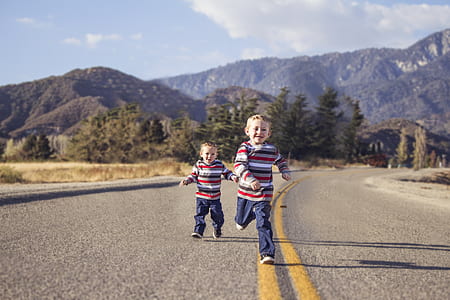 twin wearing gray, red, and white striped long-sleeved shirt and blue pants during daytime thumbnail