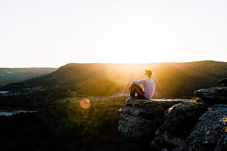 man sitting on gray cliff thumbnail