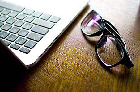 eyeglasses with black frame beside MacBook Pro thumbnail