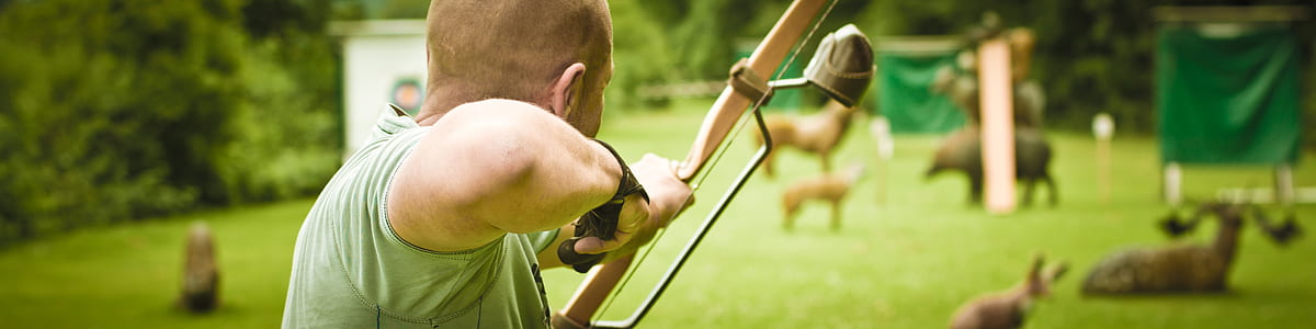 man using composite bow aiming at animals thumbnail