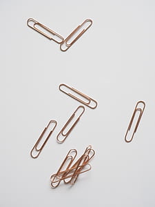brown metal paper clips on white surface thumbnail