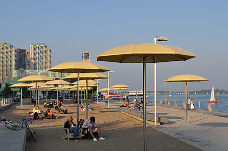 people under umbrellas near body of water thumbnail