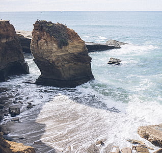 brown rock formation near cliff side overlooking sea thumbnail