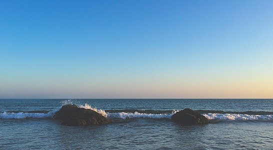 brown rocks on body of water \ thumbnail