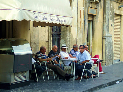 men sitting on chair beside Gelateria restaurant thumbnail
