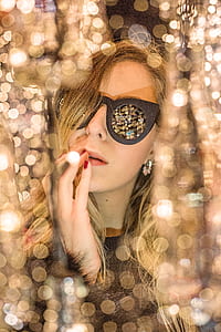 blonde haired woman wearing sunglasses with orbs of light background thumbnail