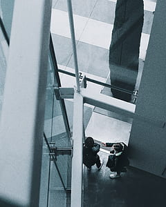 two man standing beside white painted wall thumbnail