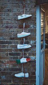 five unpaired shoe tied up on brick wall thumbnail