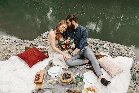 Couple Sitting Beside Calm Body of Water thumbnail