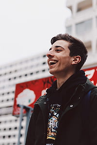 man in black collared top laughing thumbnail