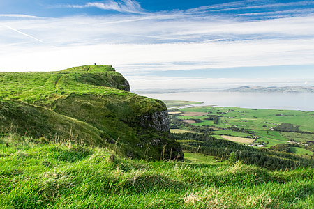 landscape photography of hill under cloudy sky thumbnail