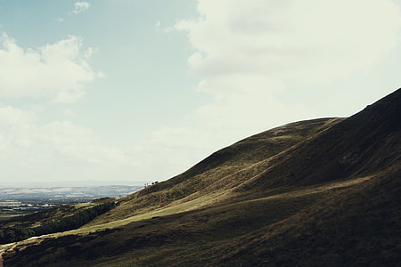 green hills beside body of water thumbnail