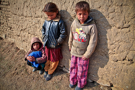 three children leaning on brown concrete wall photo thumbnail