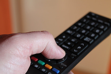 person pressing remote control thumbnail