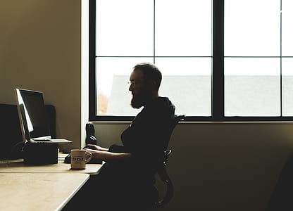 man sitting on black armchair front of silver iMac thumbnail