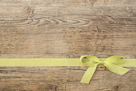 yellow and white plaid ribbon lace on brown wooden surface thumbnail