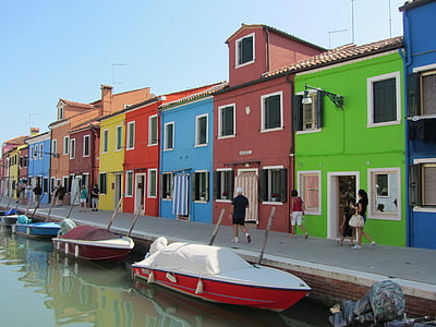 person walking on dock beside boats thumbnail