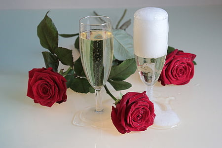 two champagne glasses and three red rose flowers thumbnail