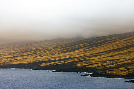 brown and black mountain near body of water thumbnail