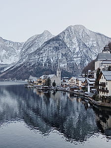 town next to mountains and body of water thumbnail