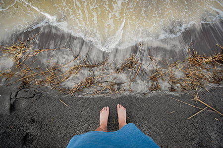 person standing front of sea wave at daytime thumbnail