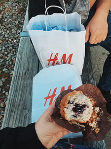 Person Holding Muffins Near the Two White H&m's Paper Bags thumbnail