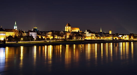 lighted city near body of water thumbnail