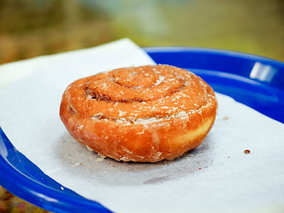 A close up shot of an orange roll sitting on a blue plate thumbnail