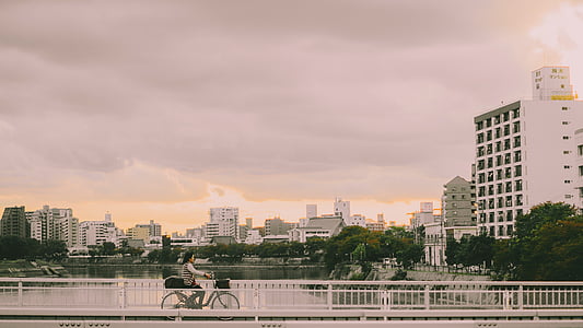 photography of person riding a bike on bridge thumbnail