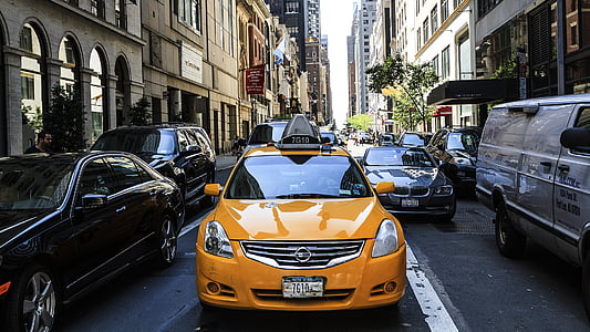 yellow Nissan taxi on road thumbnail