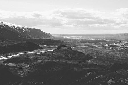 grayscale photo of body of water and rock formatio n thumbnail