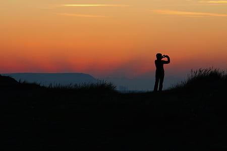 silhouette of person standing on mountain thumbnail