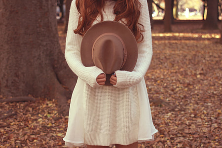 woman holding brown fedora hat shallow focus photography thumbnail