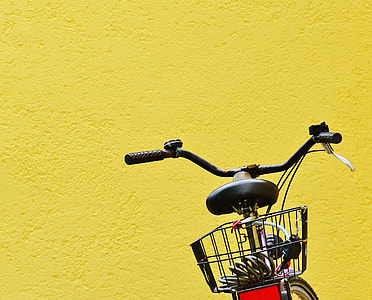 black and red bicycle parked near yellow concrete wall thumbnail